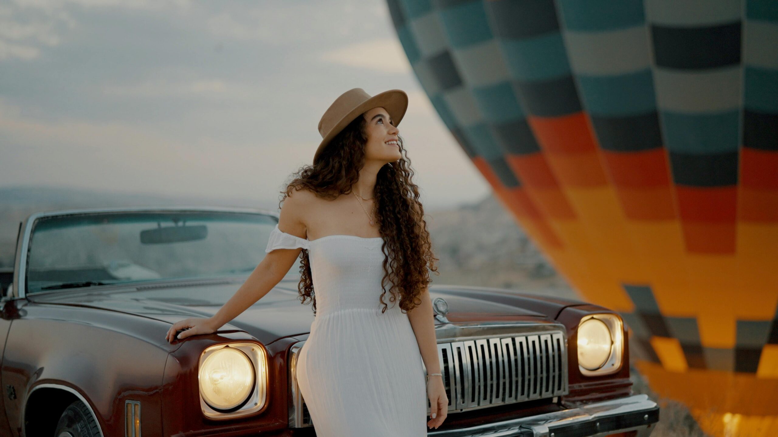 "Vintage classic car parked in Cappadocia at sunrise"
"Romantic couple enjoying a classic car tour in Cappadocia"
"Red vintage Chevrolet in Love Valley Cappadocia"